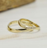 s字ラインにひねりを加えてダイヤを留めたゴールド製のシンプル結婚指輪