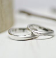 マットと光沢がひねりの境界線で折り合うシンプルな結婚指輪